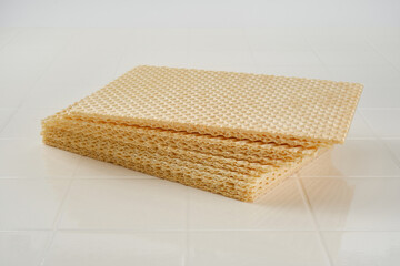 Close up of stack of wafer or waffle sheets on a white table. Shallow depth of field