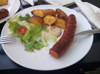grilled sausages with potatoes and salad