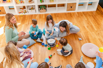 Parents taking part in the music class of a kindergarten. Teacher and parents working together....