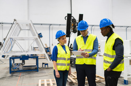 multiracial people workers in robotics company, smiling engineers standing with digital tablet
