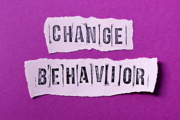 Change behavior words on pink torn paper. Motivation and self-development concept.