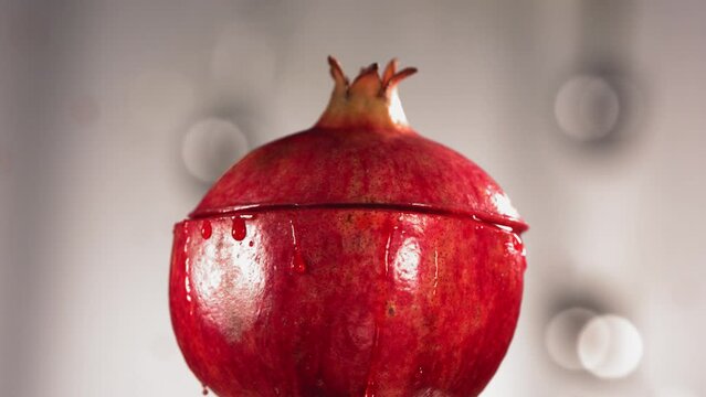 Half Pomegranate falling and splashing on white background. Food levitation concept. Slow Motion