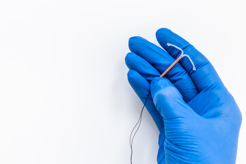 T-shaped intrauterine contraceptive device in gynecologist hand - obrazy, fototapety, plakaty