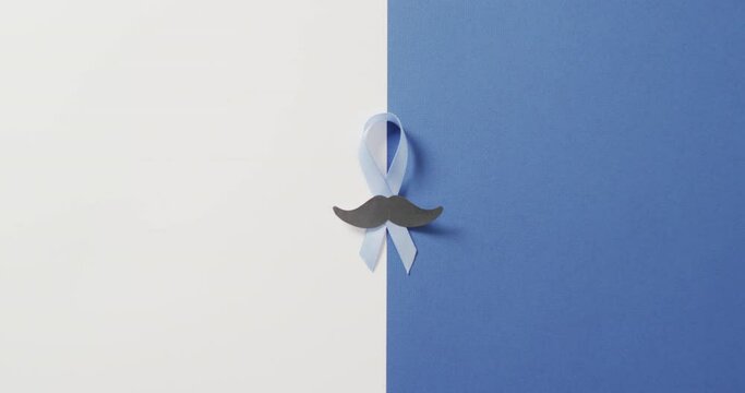 Video of paper moustache and pale blue prostate cancer ribbon on white and blue background