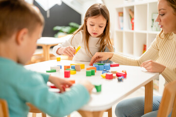 Kindergarten children playing with colorful building blocks. Healthy learning environment. Learning through play.