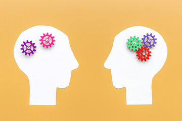 Brain work - gears on two paper human heads. Teamwork concept