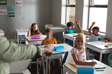 Cropped hand of african american young male teacher pointing caucasian schoolgirl with hand raised