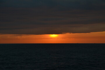 An orange-pink sunset over the water.