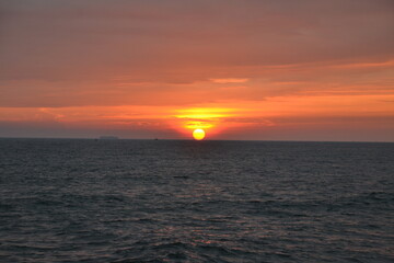 Obraz premium An orange-pink sunset over the water.