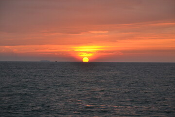 An orange-pink sunset over the water.