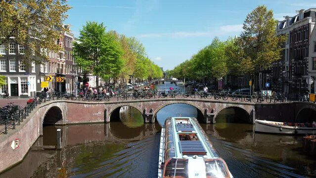 Canals with boats in Amsterdam, Netherlands. Aerial view of famous places, streets and canals. Old centre district and typical dutch architecture in Holland.