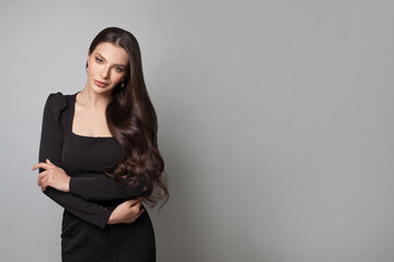 Pretty woman brunette wearing black fashionable dress posing on white background