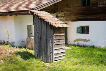 Fototapeta na wymiar Wooden farmhouse in Bavaria with many details from the roof to wooden windows and doors