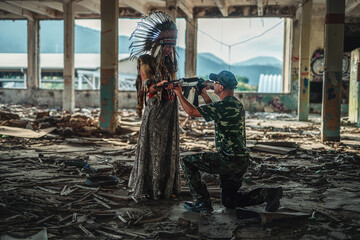 Airsoft soldier and indian woman in the old industry building.