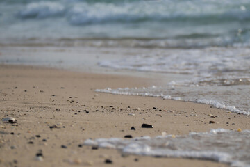 Close-up of sea waves on a sandy beach in Dubai, partially out of focus