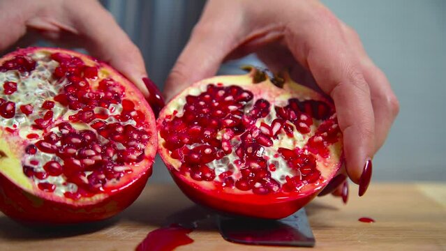 Women cuts a pomegranate with a knife