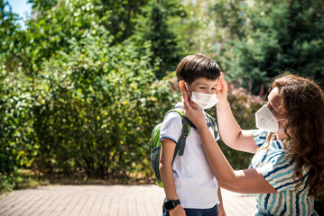 Family with kids in face mask going to school or kindergarten. Mother and child wear facemask during coronavirus and flu outbreak. Virus and illness protection, hand sanitizer in public crowded place
