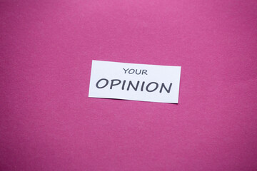 piece of paper with the phrase Tu Opinión (Your opinion) on a magenta background.