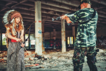 Airsoft soldier and indian woman in the old industry building.