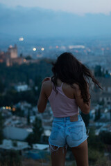 Young girl with her back turned looking at the alhambra - obrazy, fototapety, plakaty