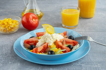 Colorful fresh vegetable salad with mozzarella cheese in bowl and orange juice. Healthy food concept