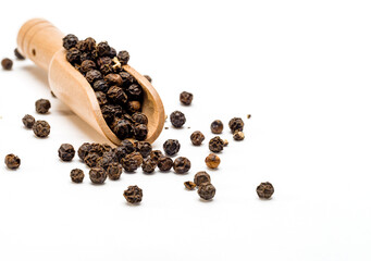 Whole Black Peppercorns in a wooden scoop poon isolated on a white background