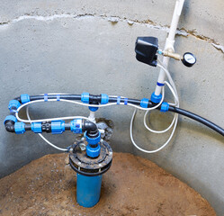 Concrete draw-well with pumping station for supplying water to house, pipes and connections