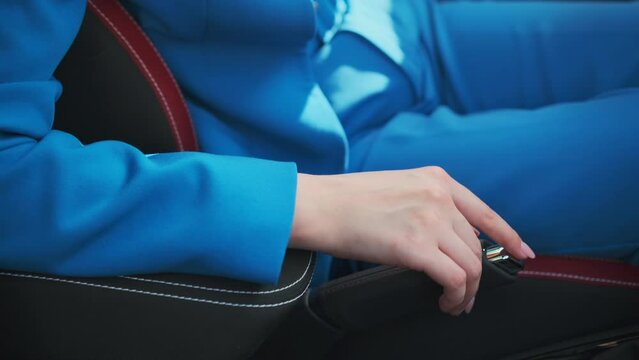 Close up woman tapping her finger on the handbrake. 