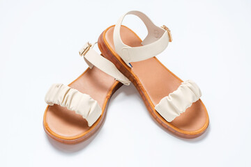 Female beige sandals on a white background close-up.