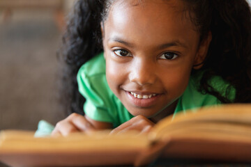 Close-up portrait of smiling african american elementary schoolgirl in school - obrazy, fototapety, plakaty