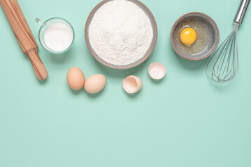 Baking ingredients on mint blue pastel background. Baking background. Top view, flat lay, copy space.