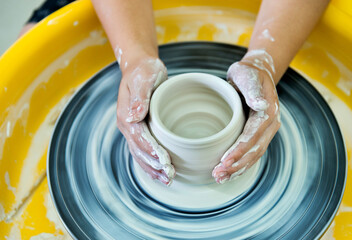 Young boy making a pitcher of clay