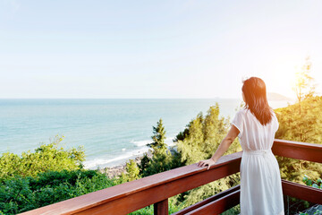 Young woman enjoying sea view  in balcony.