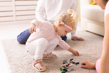 Cochlear implant for baby. Deaf child with hearing aid plays in living room. - obrazy, fototapety, plakaty