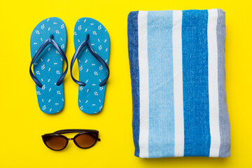 Summer travel concept. Flip flops, sunglasses and starfish on white. Top view on colored background