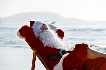 Christmas santa claus lying on a beach chair.