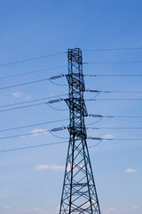 High voltage transmission tower over blue sky.
