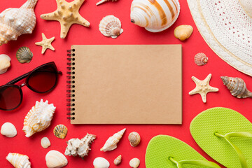 Blank writing book with summer beach accessories on background, copy space. Flat lay with copy space