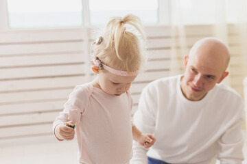 Cochlear implant for baby. Deaf child with hearing aid plays in living room.