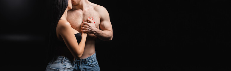 Cropped view of sexy woman touching shirtless man on black background, banner.