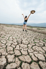 woman walking in dryland with drought ground texture. concept climate changed.