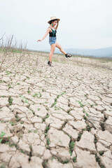 woman walking in dryland with drought ground texture. concept climate changed.