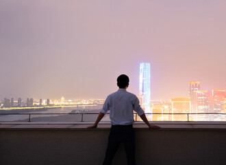 Businessman standing on the rooftop and looking away