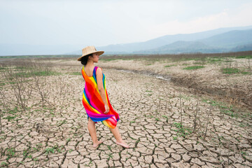 woman walking in dryland with drought ground texture. concept climate changed.