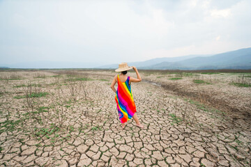 woman walking in dryland with drought ground texture. concept climate changed.