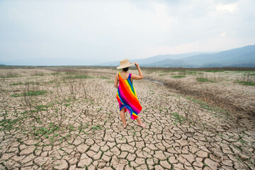 woman walking in dryland with drought ground texture. concept climate changed.