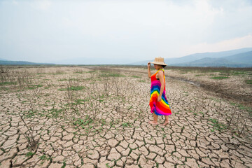 woman walking in dryland with drought ground texture. concept climate changed.