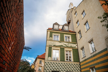 Fototapeta na wymiar Warsaw, Poland, 13 October 2021: picturesque street with colorful buildings in historic center in medieval city, renaissance and baroque historical buildings near Barbican fortifications, sunny day