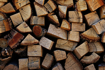 Close up shot of chopped wood logs stacked in a pile. Heap of dry timber. Patterns of wooden stumps. Close up, copy space, background.