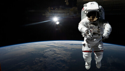Naklejka premium Astronaut in outer space over the planet Earth. Our home. ISS. Elements of this image furnished by NASA.